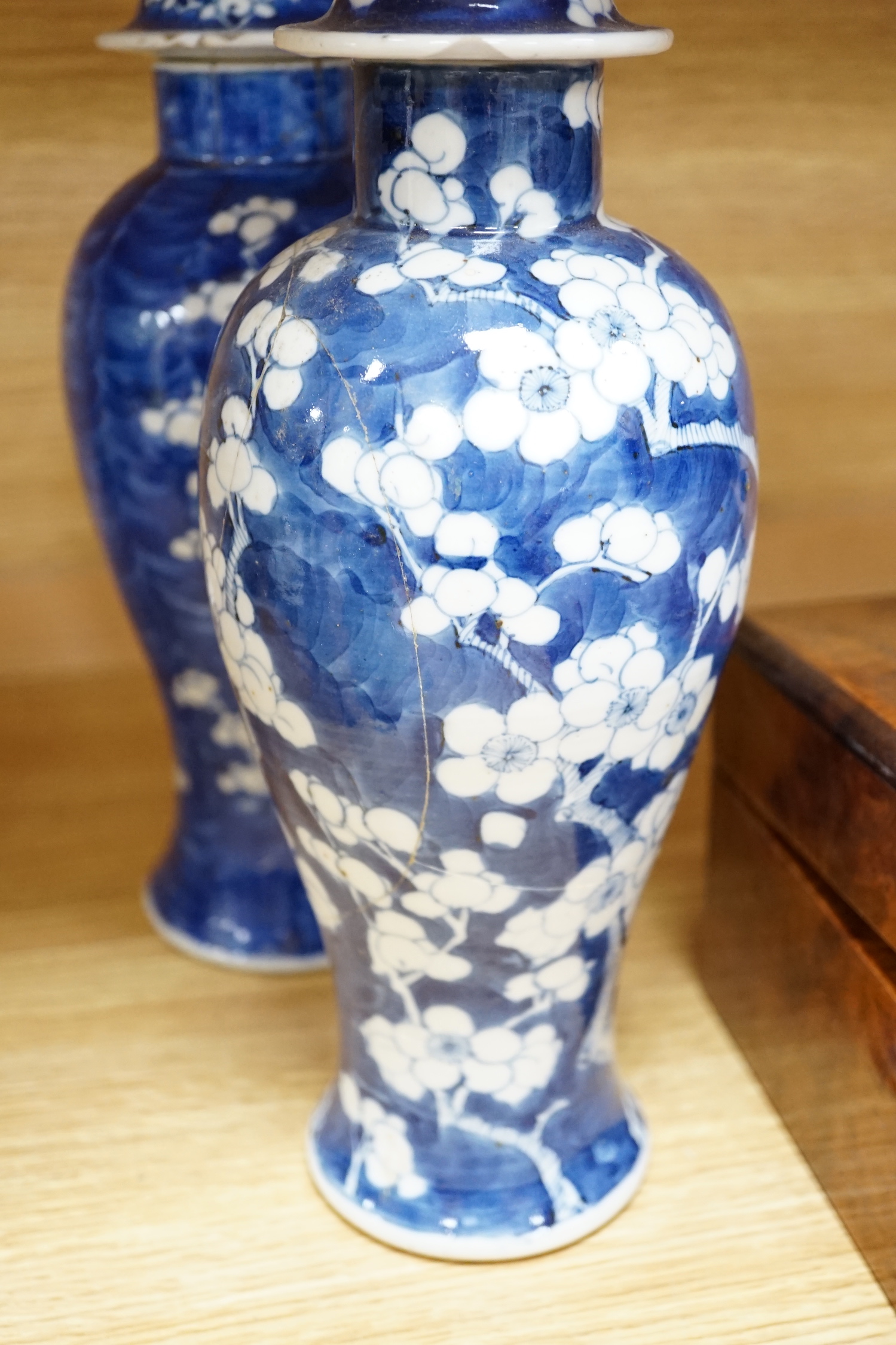 Five early 20th century Chinese blue and white prunus vases and covers, tallest 31cm